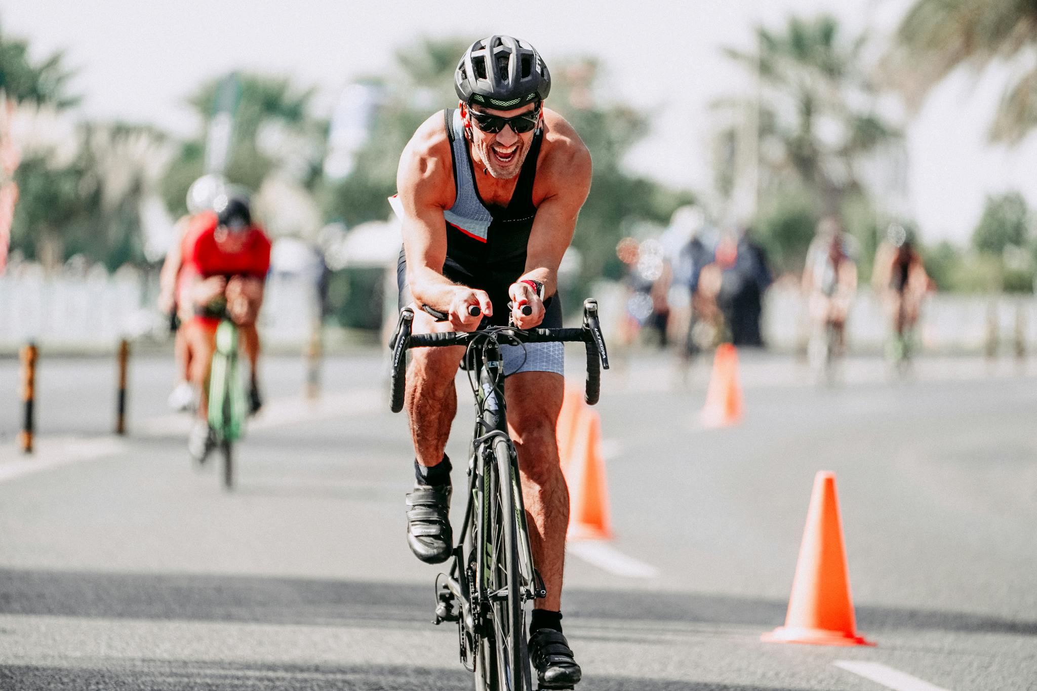 A male cyclist competes in a triathlon, showcasing determination on an urban roadway.