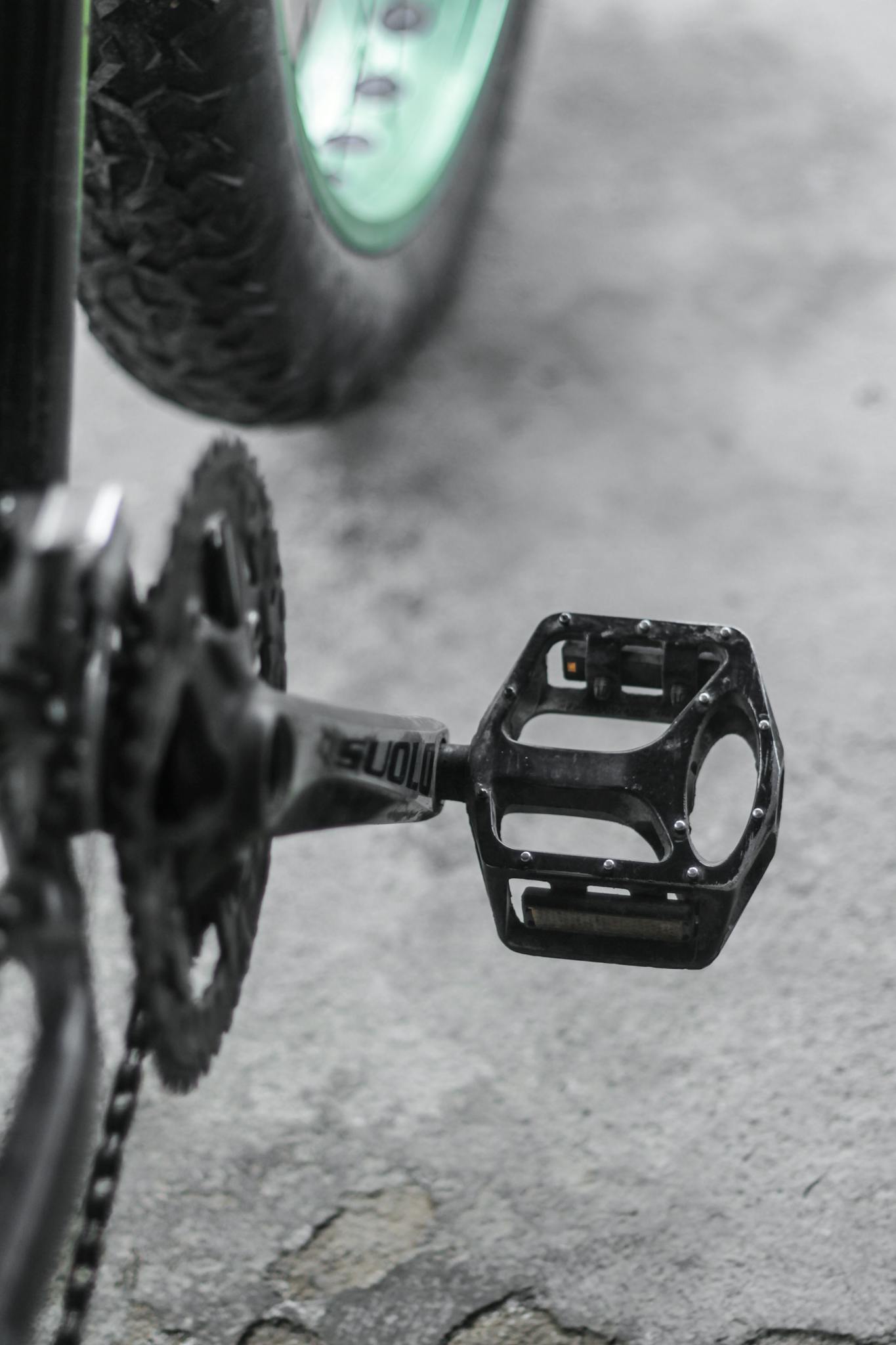 Detailed close-up of a mountain bike pedal and chain showing gear mechanism.