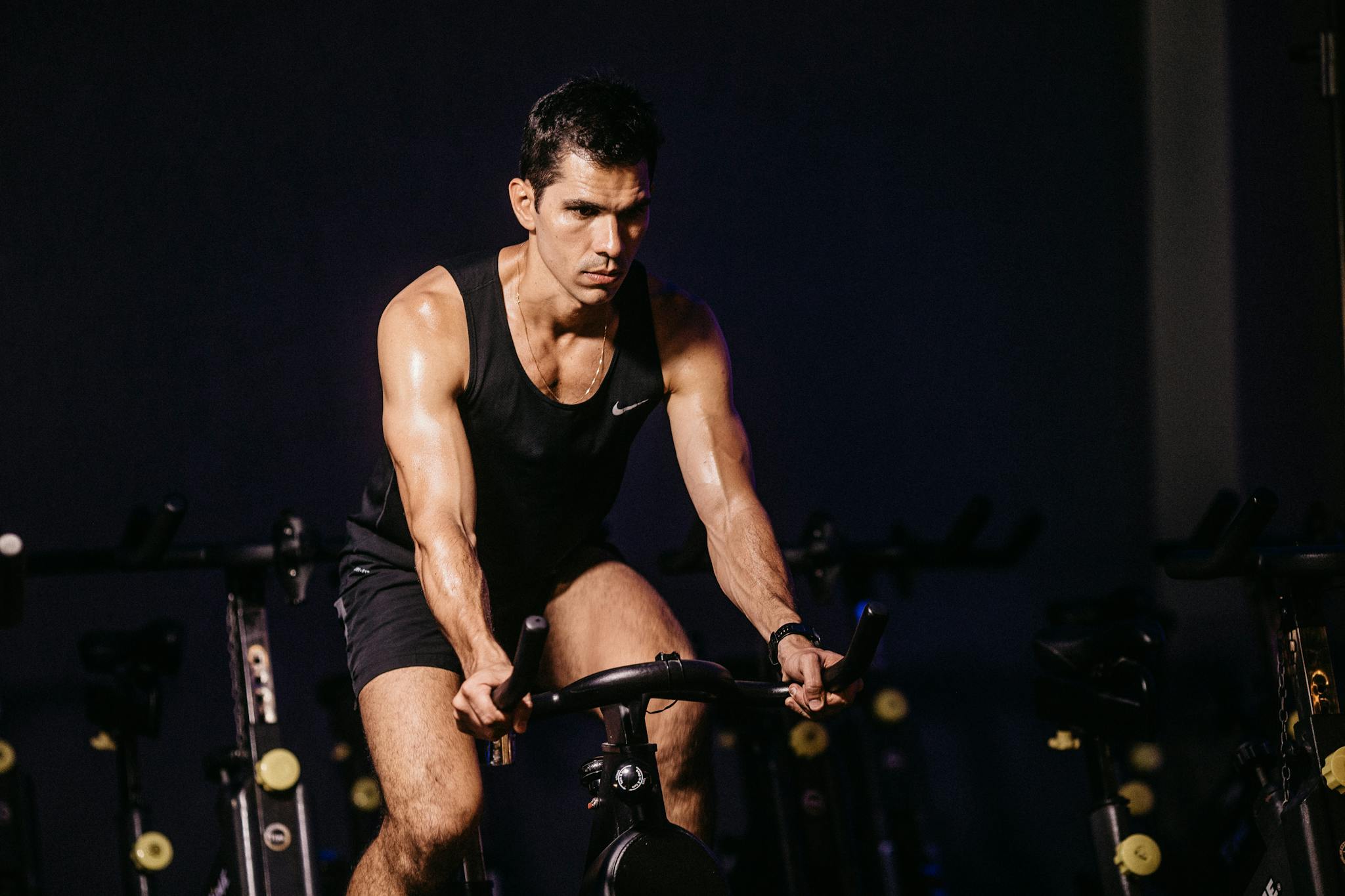 Focused man engaging in a vigorous indoor cycling session, showcasing fitness and determination.